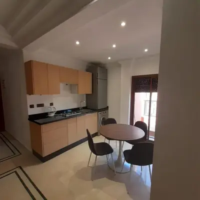 a kitchen with a table and chairs in a room at APPARTEMENT JAWHARA HIVERNAGE in Marrakech