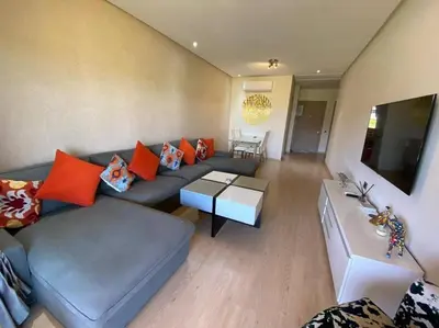 a living room with a blue couch and orange pillows at Marrakech Prestigia Golf City - beauty Appartement in Marrakech