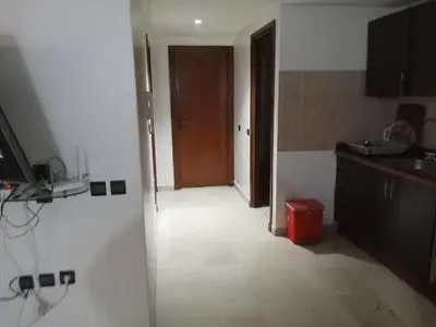 a room with a hallway with a door and a kitchen at Nic's apartment in Marrakech