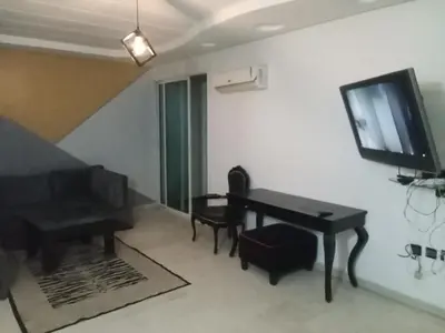 a living room with a piano and a television at Nic's apartment in Marrakech