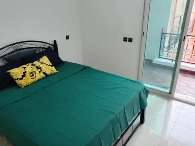 a green bed in a room with a window at Nic's apartment in Marrakech