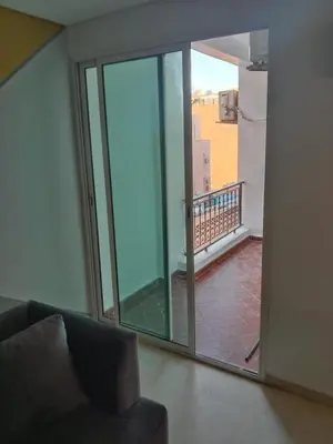 a living room with a sliding glass door to a balcony at Nic's apartment in Marrakech
