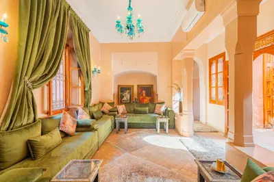 a living room with a couch and a chandelier at Villa les oliviers in Marrakech