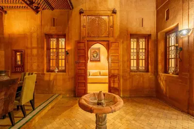a living room with a table in the middle of a room at Villa les oliviers in Marrakech