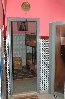 a room with a door leading into a room with a bedroom at kech hostel in Marrakech
