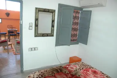 a bedroom with a bed and a mirror and a table at kech hostel in Marrakech