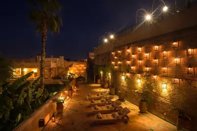a group of tables in a courtyard at night at Palais Riad Lamrani in Marrakech