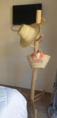 two straw hats on a wooden stand next to a bed at Appartement gueliz 2 chambres in Marrakech