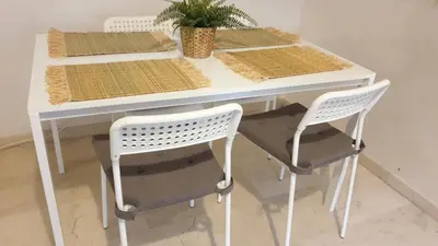 a white table with two chairs and a plant on it at Appartement gueliz 2 chambres in Marrakech