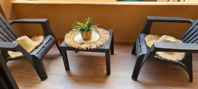 three chairs with a table with a potted plant on them at Appartement gueliz 30 in Marrakech