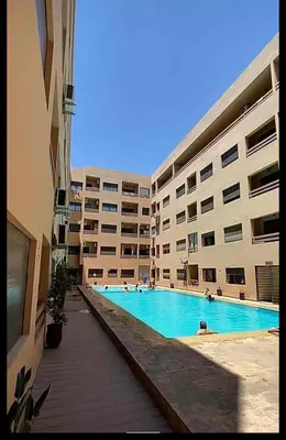 a large apartment building with a large swimming pool at Appartement gueliz 30 in Marrakech