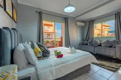 a bedroom with a large white bed and a couch at Grand Cozy Apartment in Heart of Hivernage in Marrakech