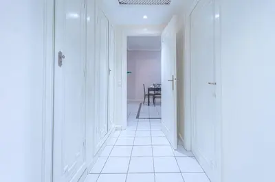 a hallway with white walls and a white tile floor at Grand Cozy Apartment in Heart of Hivernage in Marrakech