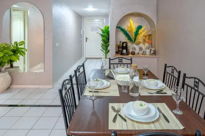 a dining room with a wooden table and chairs at Grand Cozy Apartment in Heart of Hivernage in Marrakech