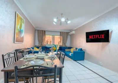 a living room with a table and a couch at Grand Cozy Apartment in Heart of Hivernage in Marrakech