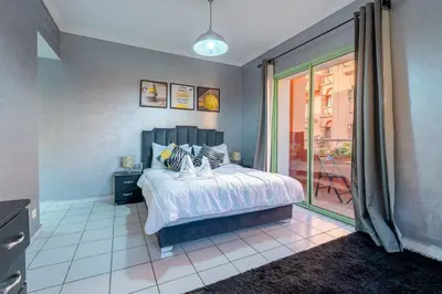a bedroom with a bed and a sliding glass door at Grand Cozy Apartment in Heart of Hivernage in Marrakech