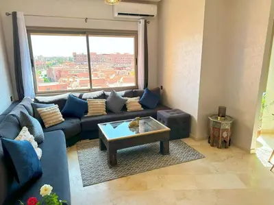 a living room with a blue couch and a table at Appart Majorelle terrasse wifi centre ville in Marrakech