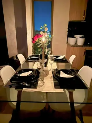 a dining room table with a candle and a table with chairs at Appart Majorelle terrasse wifi centre ville in Marrakech
