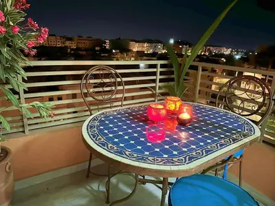 a table on a balcony with candles on it at Appart Majorelle terrasse wifi centre ville in Marrakech