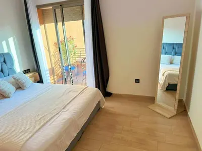 a bedroom with a large bed and a mirror at Appart Majorelle terrasse wifi centre ville in Marrakech