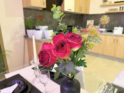 a vase filled with red roses on a table at Appart Majorelle terrasse wifi centre ville in Marrakech