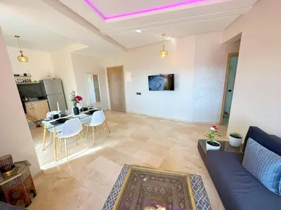a living room with a blue couch and a table at Appart Majorelle terrasse wifi centre ville in Marrakech