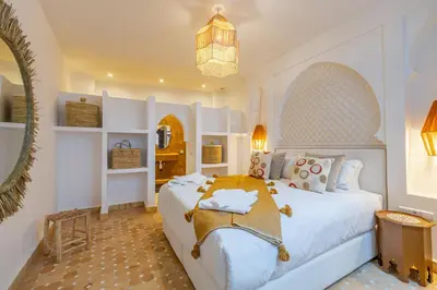 a bedroom with a large white bed and a chandelier at Riad Dar Lalla Saadia-Exclusiv-HeatedPool-Breakfast in Marrakech