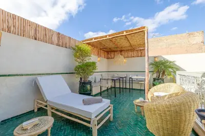 an outdoor patio with chairs and tables and a table at Riad Agan Exclusive with New Heated Pool and Breakfast included in Marrakech
