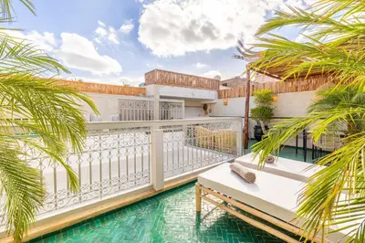 a balcony with a pool and palm trees at Riad Agan Exclusive with New Heated Pool and Breakfast included in Marrakech