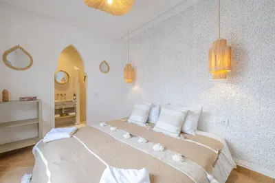 a white bedroom with a large bed with white pillows at Riad Agan Exclusive with New Heated Pool and Breakfast included in Marrakech