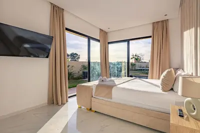 a bedroom with a large bed and a large window at Villa Victoria, piscine Chauffée, sans vis à vis in Marrakech
