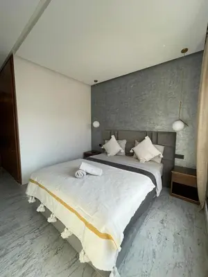 a bedroom with a large bed with two towels on it at Appartement 2 ch in Marrakech