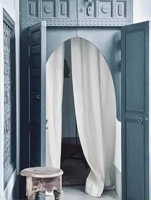 a room with a doorway with a table and a curtain at Riad Atay in Marrakech