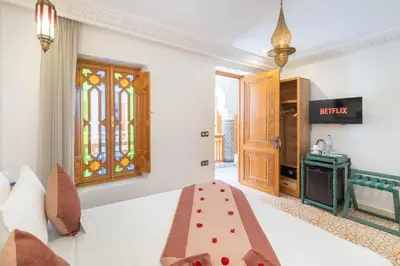 a bedroom with a bed and a stained glass window at Riad Atlas Palace & SPA in Marrakech