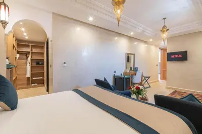 a hotel room with a large bed and a living room at Riad Atlas Palace & SPA in Marrakech