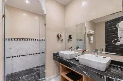 a bathroom with two sinks and a shower at Riad Atlas Palace & SPA in Marrakech