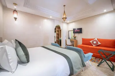 a hotel room with a bed and a couch at Riad Atlas Palace & SPA in Marrakech