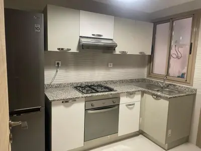 a small kitchen with a stove and a sink at Appartement Coralia in Marrakech