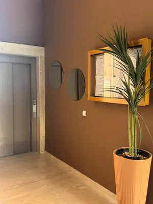 a plant in a pot on a wall with mirrors at Les Palmier de targa, Romantic appartement in Marrakech