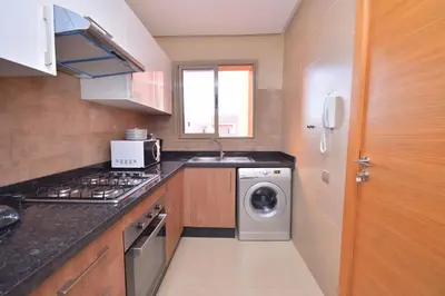 a kitchen with a washing machine and a sink at Appartement Prestigia Golf City Marrakech in Marrakech