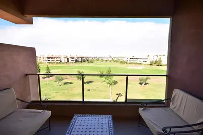 a room with a view of a golf course from a window at Appartement Prestigia Golf City Marrakech in Marrakech