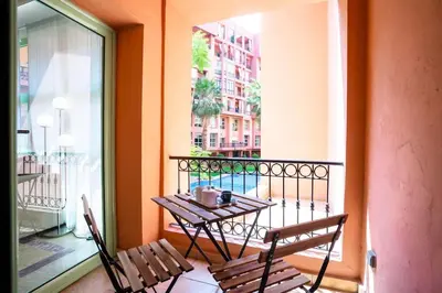 a balcony with a table and chairs on a balcony at Duplex Majorelle Marrakech in Marrakech