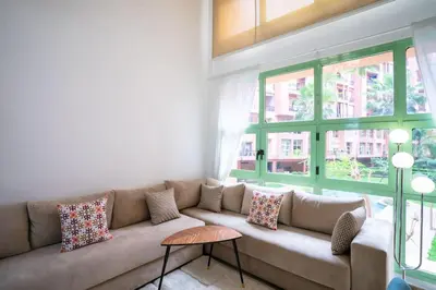 a living room with a couch and windows at Duplex Majorelle Marrakech in Marrakech