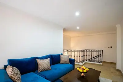 a blue couch in a living room with a bowl of fruit on a table at Duplex Majorelle Marrakech in Marrakech