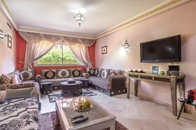 a living room filled with furniture and a flat screen tv at MAJORELLE APPARTEMENT FAMILIAL in Marrakech