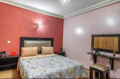 a bedroom with a bed with a red wall at MAJORELLE APPARTEMENT FAMILIAL in Marrakech
