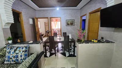 a living room with a dining table and a television at Appartement C à 7 min de l’aéroport de Marrakech in Marrakech