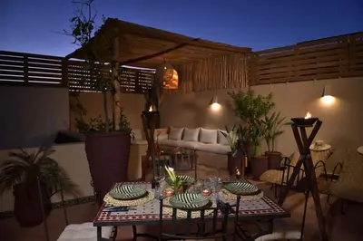 a patio with a table and chairs and a couch at Riad Palau Marrakech in Marrakech