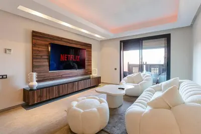 a living room with white furniture and a flat screen tv at Majestic Splendor - Marrakech Centre in Marrakech