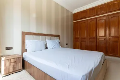 a bedroom with a large bed and a wooden cabinet at Royal mirage villa(families only) in Marrakech